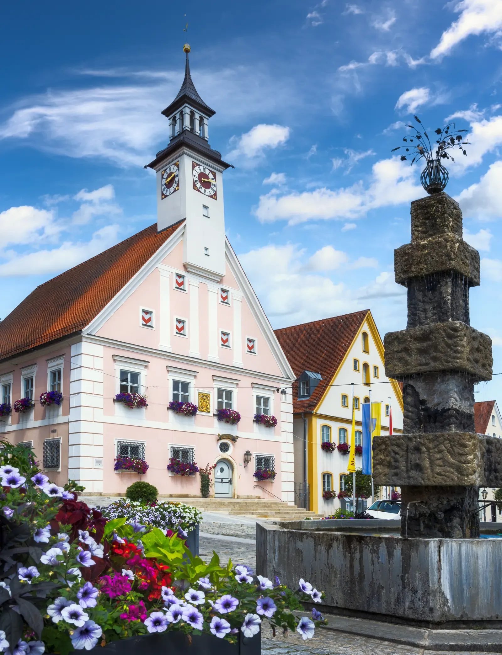 Rathaus mit Uhrturm und Blumenschmuck am Marktplatz, Sinnbild für Kommunen und Bildung