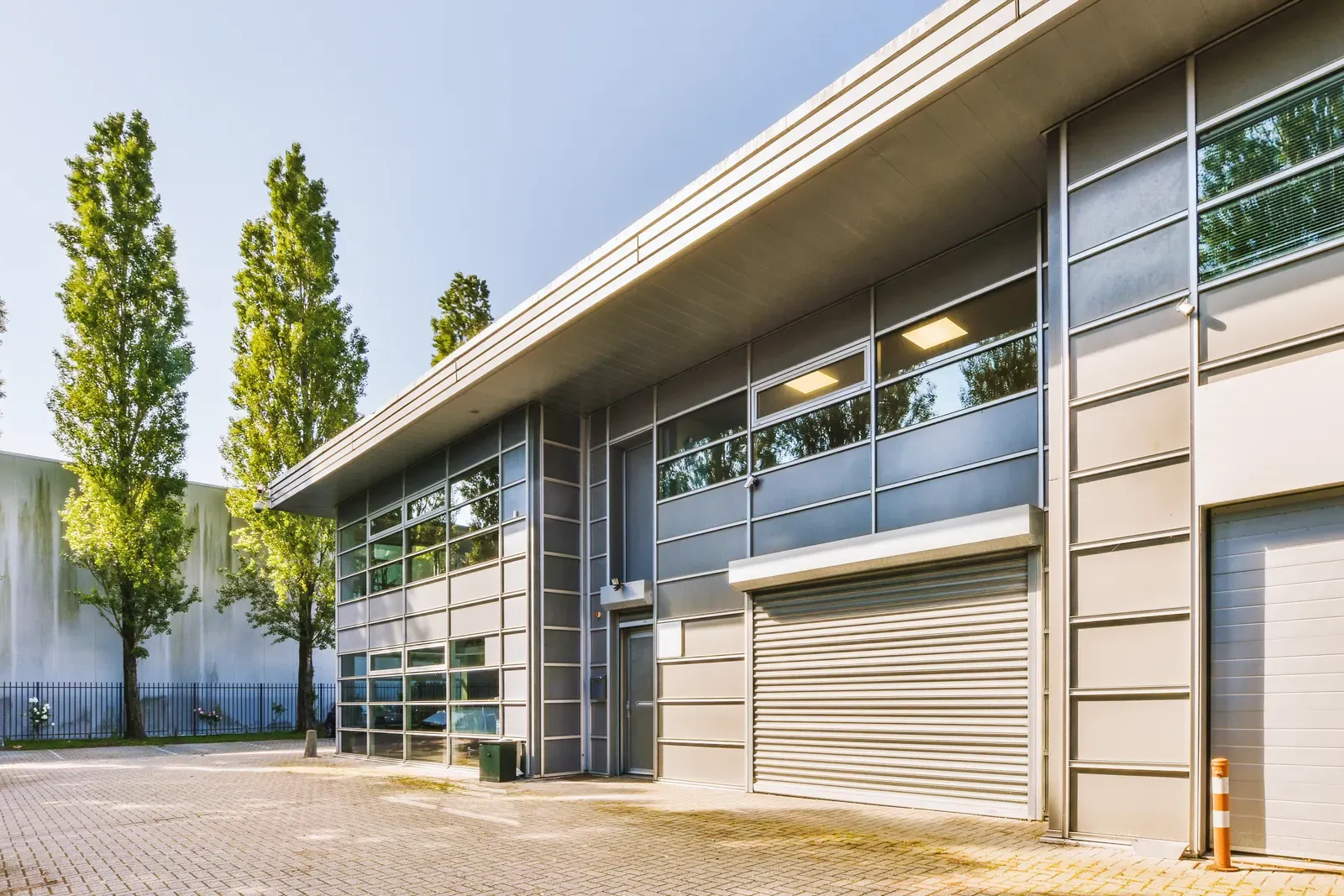 Moderner Gewerbebau mit Bürotrakt und Rolltoren, Sinnbild für Unternehmen und Betriebe